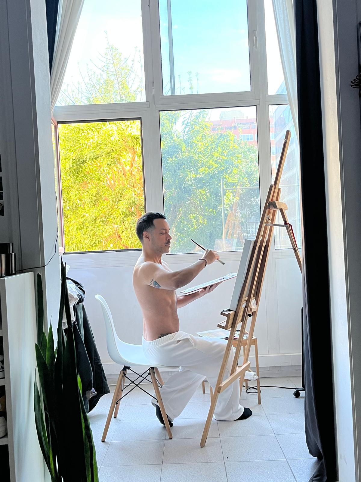 André Bazaga pintando diante da janela do seu ateliê em Barcelona